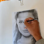 Depois de completado esse procedimento, você irá virar a página e usando um lápis grafite de preferência duro, começa a cobrir toda a imagem, dando máxima atenção aos olhos, no qual é o elemento principal nesse tipo de trabalho. Uma observação importante no caso da barra de grafite que irá riscar toda a folha atrás, esse grafite precisa ser macio, pelo menos 8B, para que os riscos fiquem mais escuros e definidos no momento de riscar os traços, a imagem que aparecerá será mais nítida. E o lápis grafite para efetuar o desenho de preferência duro, como o que uso nesse trabalho, o 6H, para que possa vincar bem e deixar a marca do grafite na folha que está sendo usada.